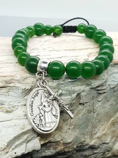 Jade Rosary bracelet with your choice of Catholic saint and crucifix.   Photo shows Guardian Angel medal. Bracelet is natural Jade and will have some natural variation in colour. The photos on my listing are a good representation of the quality of the Jade. Adjustable bracelet with square knot closure. Saint medallion and crucifix are made in Italy. Your choice of saint plus the corpus crucifix.  The charms will be soldered on to your bracelet so they won't be lost.  All knots are secured.  Plea Adjustable Crucifix Spiritual Bracelet, Adjustable Green Spiritual Rosary Bracelet, Catholic Saint, Square Knot, Rosary Bracelet, Natural Jade, Custom Bracelets, Guardian Angel, Adjustable Bracelet