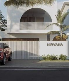 a red car parked in front of a white building with a sign that says nirvana on it