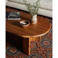 a wooden table with a plant in a bowl on it and a book next to it