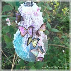 a group of butterflies hanging from the side of a bird feeder on a tree branch