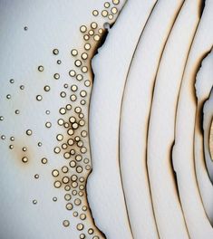 a clock sitting on top of a white plate covered in gold dots next to a bottle of wine