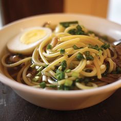 a bowl of noodles with an egg on top and green onions in the middle is featured for instagram