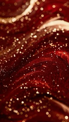 red and gold glitter fabric with small white dots on the top right corner, as well as an abstract background