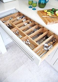 an open drawer in a kitchen filled with silverware