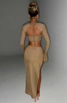 the back of a woman's dress is shown, with her hands on her hips