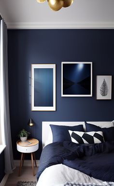 a bedroom with dark blue walls and white bedding, artwork on the wall above