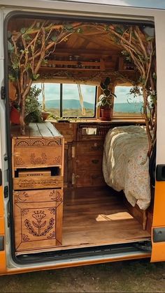 the interior of a van with a bed and dresser in it's back door