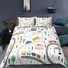 a bed with a train themed comforter and pillow cases on top of it in a bedroom