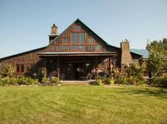 a large house sitting on top of a lush green field