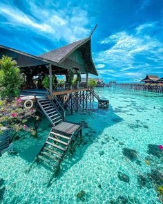 a house on stilts in the water with stairs leading to it