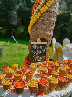 there are many small pots on the table with flowers in them and a sign that says shower the couple