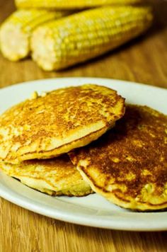 two pancakes on a white plate sitting on a wooden table