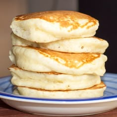 a stack of pancakes sitting on top of a blue and white plate