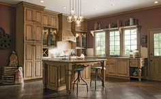 a large kitchen with wooden cabinets and stools next to an island in the middle