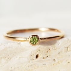 A dainty birthstone ring, made with 14k gold fill or Sterling Silver! Set with one imitation birthstone gemstone to personalize and customize your birthstone jewelry to something special to you! ∙ Gift Ready in a jewelry box! ∙ Handmade in Vancouver, Canada.  ∙ 100% 14k Gold Fill or Sterling Silver ∙ Rings Sold Individually --------------------------------- M E A S U R E M E N T :  Width: 1.25mm  Gemstone: 3mm Size: Optional (US measurement) If your ring size is not specified as an option, pleas Stackable Peridot Birthstone Ring For Anniversary, Peridot Solitaire Birthstone Ring For Promise, Peridot Solitaire Birthstone Ring, May Birthstone Peridot Solitaire Ring, Peridot Solitaire Ring For May Birthstone, Gold Stackable Rings With Peridot Birthstone, Gold May Birthstone Ring With Round Stone, Gold Birthstone Ring For May With Round Stone, Peridot Birthstone Ring For Promise