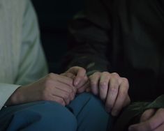 two people holding hands while sitting next to each other