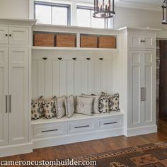 a room with some white cabinets and lots of pillows