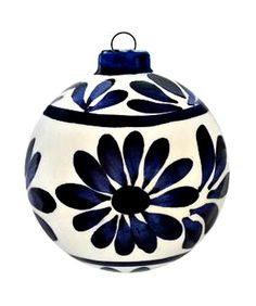 a black and white ornament with blue flowers on it's side, in the shape of a ball