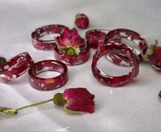 red glass rings and flowers on a white cloth