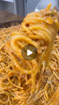 a spoon full of spaghetti being held by someone