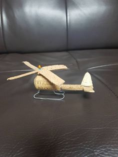 a toy helicopter sitting on top of a black leather couch next to a bottle opener