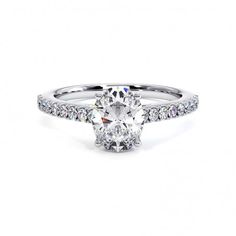 an oval cut diamond engagement ring with pave set shoulders