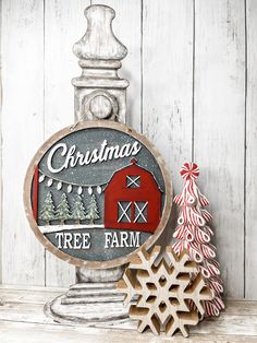 a christmas tree farm sign next to a snowflake on a white wooden background