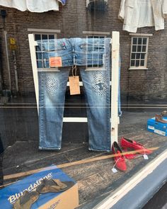 a pair of jeans and shoes are on display in a window