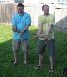 two men standing in the grass holding something