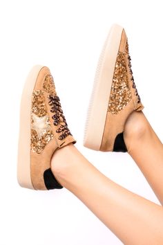 Step up your shoe game with the Another Round Sneakers in Gold Sequins! These faux suede sneakers feature eye-catching sequin embellishments and a lace closure for a secure fit. With a rubber sole and cushioned insole, you'll be walking in style and comfort while the star detail adds a playful touch. Ships within 2-3 business days. Faux Suede Gold Sequin Embellishments Lace Closure Rubber Sole Star Detail Cushioned Insole Athleisure Tops, Gold Sequin, Gold Sequins, Waterproof Jewelry, Suede Sneakers, Lace Closure, Shoe Game, Hat Hairstyles, Faux Suede