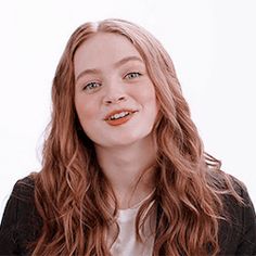 a woman with long red hair wearing a black jacket