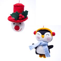 two christmas ornaments hanging from strings on a white background, one penguin wearing a hat and the other with a scarf around its neck