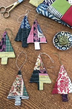 several pieces of fabric and scissors on a wooden table with various items to sew