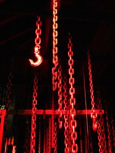 red chains hanging from the ceiling in front of a clock