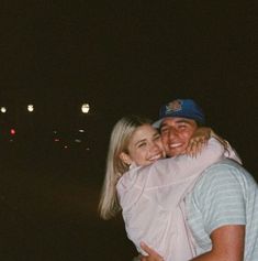 a man hugging a woman on the street at night