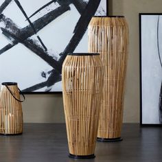 three large vases sitting next to each other on top of a wooden table in front of a painting