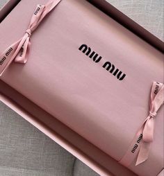 an open pink box with ribbon on the side and words written in black across it