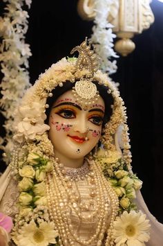 a close up of a statue of a woman with flowers in her hair and makeup