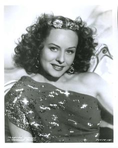 an old black and white photo of a woman wearing a dress with sequins