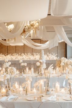 a room filled with lots of tables covered in white cloths