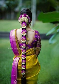 a woman in a yellow and purple sari with her hair pulled back to the side