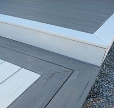 the bottom part of a wooden deck with gravel and rocks