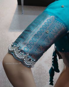 a mannequin wearing a blue dress with intricate designs on it's arm