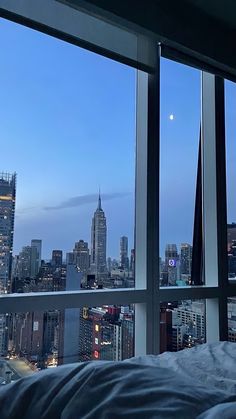 a bedroom with a view of the city at night