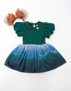 Get ready to take on the galaxy with The Space Forest Dress! This unique dress is made with a soft green cotton knit top, puff sleeves and a matching green collar. The collar features adorable embroidery details. The bottom is made of silky chiffon with tulle underlayers and features a beautiful forest design that is o Rose Princess Dress, Space Forest, Purple Tutu Dress, Teal Gown, Gown With Cape, Forest Dress, Purple Tutu, Forest Baby, Ice Dresses