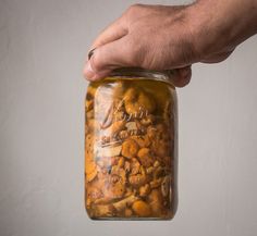 a hand holding a jar filled with food