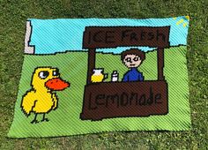 a blanket with an image of a man and a duck in front of a lemonade stand