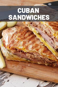 a cut in half sandwich sitting on top of a cutting board next to a knife