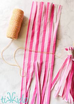 pink and white striped paper tassels with twine spools on top