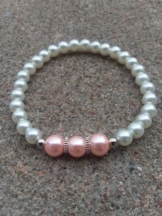 This elegant bracelet is made with white, pink, and silver beads, silver cogwheel spacers, and stretch cord. These would make lovely accessories to weddings, Easter celebrations, or any other special occasion! They also make beautiful gifts! If ordering for a child, please put so in the note section when checking out and the age of the child (bracelets shown in pictures are adult sizes). *If your wrist runs small, either message me or put something in the comment section of your purchase order to make it a little smaller* *Remember to roll stretch bracelets over the hand to preserve shape and elasticity and reduce stretching out to much* *The goal of my shop is to make available elegant, beautiful jewelry that anyone can afford so all items are $15 and under! If you see an item you like bu White 8mm Beads Bracelets For Wedding, White 8mm Beaded Bracelets For Wedding, White 8mm Beads Bracelet For Wedding, Adjustable White Charm Bracelet With Silver Beads, White Pearl Bracelet With Spacer Beads For Wedding, White Beaded Bracelets With Spacer Beads For Wedding, White Beaded Bracelet, White Beads Bracelet, Wedding Bracelets